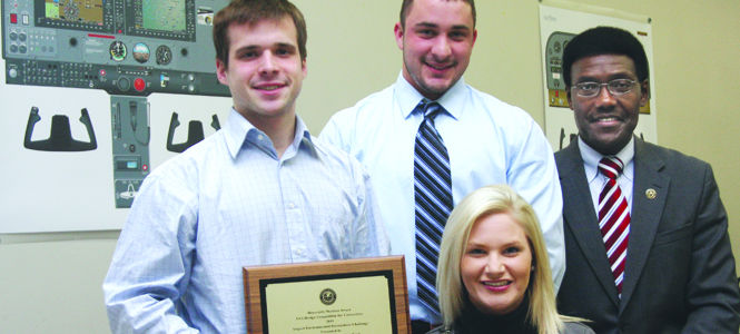 Senior aeronautics majors Joshua Mathis, Curtis Rupeka and Ashley Gordon, along with Isaac Nettey, associate dean of the College of Technology, spent four months developing a proposal to better de-ice planes, which won each of the students a $500 award. Photo by Valerie Brown.