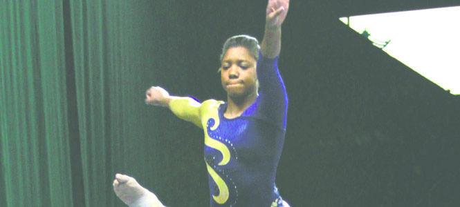 Freshman Nikki Moore performs a split in mid-air on the balance beam as she performs at a quad meet in Cleveland. She earned a 9.050 for her routine and came in 22nd overall.. Photo by Lindsay Frumker.