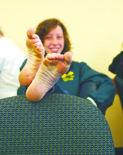 Freshman broadcast journalism major Allie Johnson goes barefoot to show her support for Toms, an organization whose goal is to get footwear to those who have none. For every pair of shoes that one buys from Toms, they will donate a pair to someone in need. Despite the cold, Johnson, and others went without shoes today to spread awareness for the cause. Photo by Sam Verbulecz.