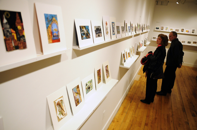 Sharon Irwin of Kent, explains the inspiration behind her winning postcard at the “Wish You Were Here” postcard show at the Downtown Gallery Friday. Irwin’s Japanese-style postcard was inspired by her husband, KSU professor John Akamatsu, and visits to Japan. Photo by Hannah Potes.