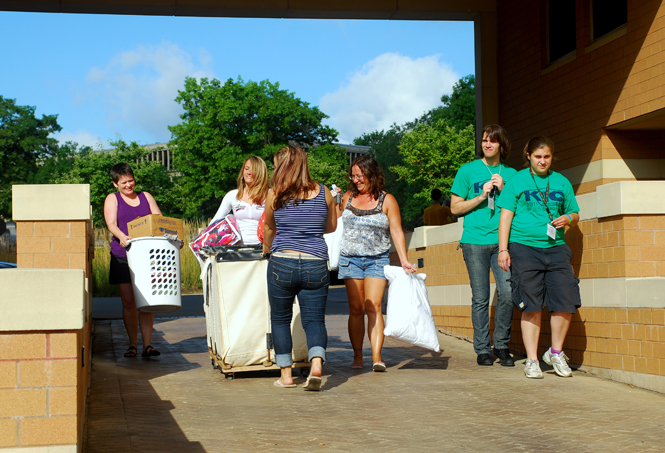 Moving is a group effort for Kent State students moving in on Thursday, Aug. 25. Whether enlisting the assistance from one’s family as Nicole Diederich, freshman exercise science major (2nd from left), did, or getting a hand from the Kent Interhall council’s Movers &amp; Groovers (green shirts, far right), help moving in is never far away. Photo by Sam Verbulecz.