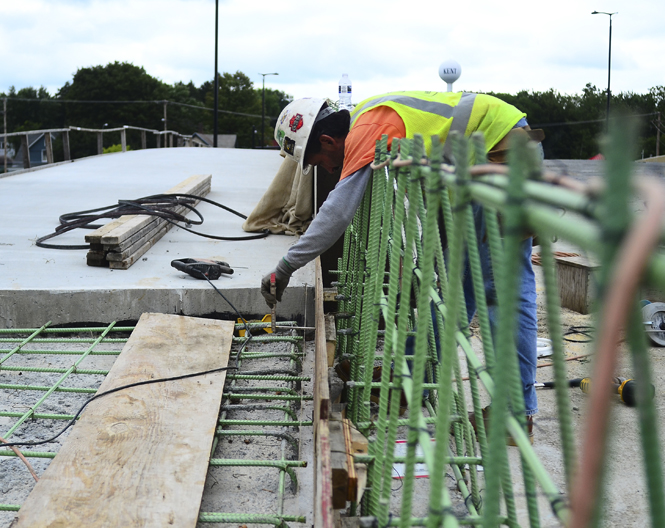 Jamie Martinez, of Beaver Excavating, works on the sidewalk that will be on the new Fairchild bridge. Photo by Jacob Byk.