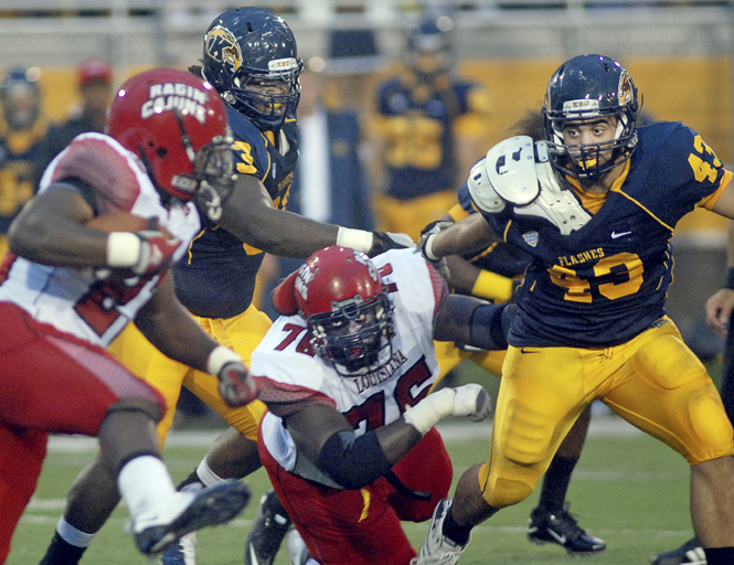 Senior defensive lineman Ishmaa'ily Kitchen and junior linebacker C.J. Malauulu rush to tackle Loiusiana's ball-carrier during Kent's loss to Louisiana on Sept. 10. Photo by Matt Hafley.