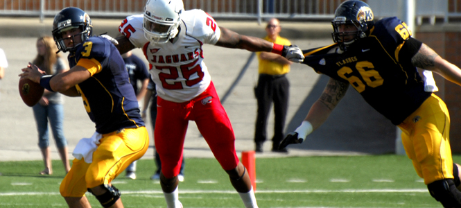 Kent State’s quarterback Spencer Keith looked for a pass while University of South Alabama’s Clifton Crews went in for a sack at Dix Stadium Saturday, Sept. 24. The Golden Flashes beat the Jaguars 33-25. Photo by Monica Maschak.