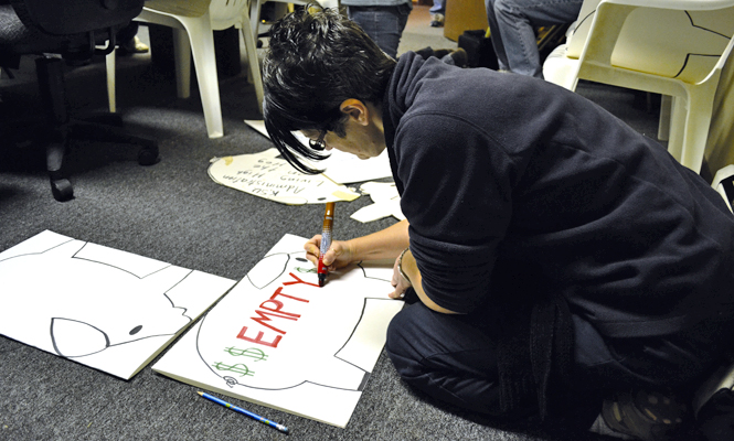 Custodian Kim Johnson helps her fellow AFSCME members make signs illustrating their financial struggles Saturday, Dec. 3. AFSCME plans to picket the Kent State graduation Dec. 17. Photo submitted by Lydia Coutré