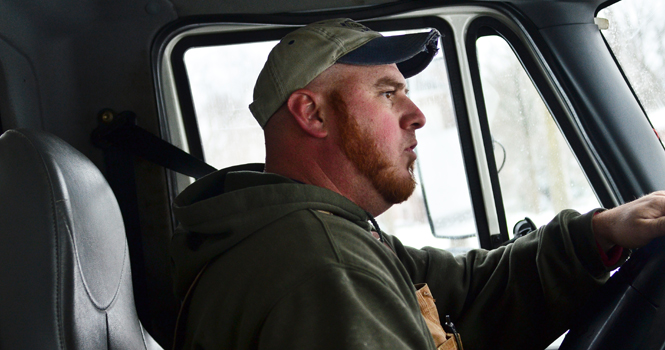 Matt Benson, a snow plow driver of four years and resident of Rootstown, in his truck on the job on Saturday, January 13th. Benson was on the last hour of a sixteen hour shift that he began at 1:00 AM when this photo was taken. Photo by Jacob Byk.