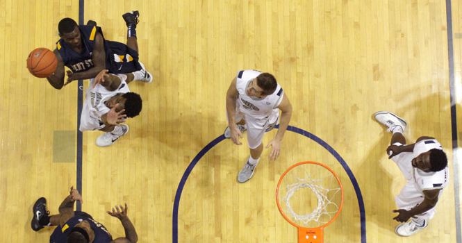 Junior guard Randal Holt attempts a shot against the Akron defense at Rhodes Arena on Jan. 21. Kent fell to Akron 84-75. Photo by Brian Smith.