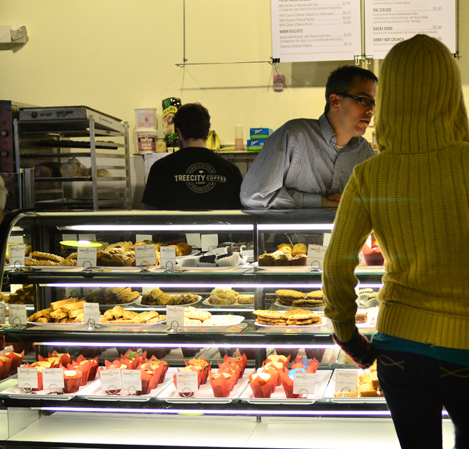 Evan Bailey, a Kent resident of 28 years, assists a customer on the opening day of his business - Tree City, on Monday, January 16th. Tree City is a cafe / bakery and is down behind Acorn Alley in downtown Kent. Photo by Jacob Byk.