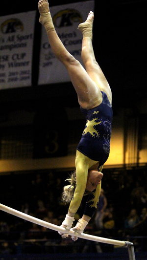 One of the Flashes' gymnasts swings on the un-even bars on January 21. Photo by Adrianne Bastas