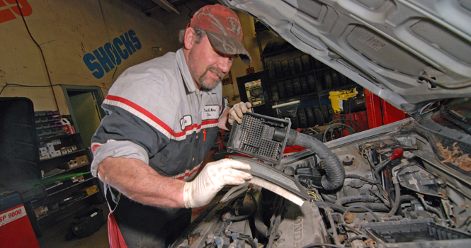 Jamie Nicely, 42, checks the air filter on a Honda Civic at Tires and More, located at 1556 South Water Street. "Keep an eye on stuff," Nicely said, noting that college students can easily check basics things such as lights, wiper blades and tire pressure to make sure their car is working properly. Nicely has worked at Tires and More for 14 years. Photo by Matt Hafley