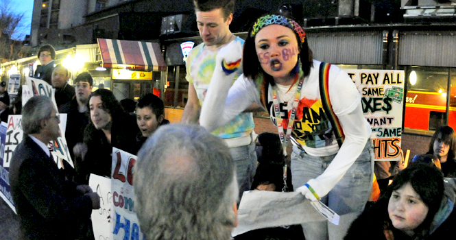 Supporters of the LGBT community lined up in protest of hate politics at the Rick Santorum dinner on Saturday, Feb. 19. Ayla Hartung, of Akron, speaks with an anti-gay Santorum supporter during the rally. Photo by Philip Botta.