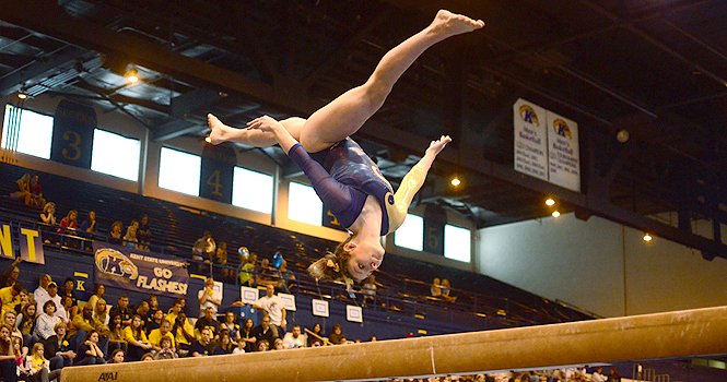 Lauren Wozniak, junior, flips on the balance beam at the meet against Cornell at the MAC on March 18. The Flashes beat the Big Red 196.025 to 192.425. Photo by Nancy Urchak.