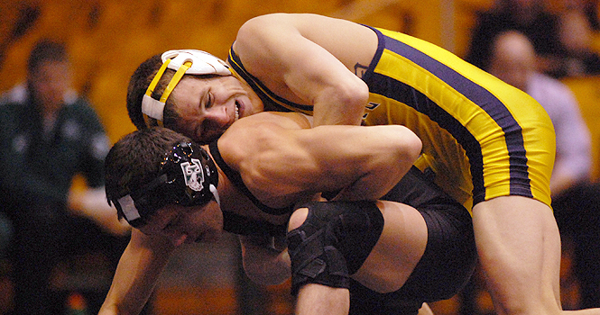 Nic Bedelyon, senior, wrestles Jared Germaine, sophomore, at the match against Eastern Michigan on Feb. 5. The Flashes won 28-10. Photo by Nancy Urchak.