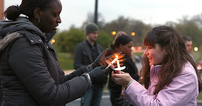 Lorriane Odhiambo lights Katelynn Dearth's candle prior to the Take Back The Night march Thursday evening. Photo by Coty Giannelli.