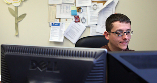 Joshua Rider, Assistant Director of the Center for Adult and Veteran Services, catches up on some work at his desk in the Michael Swartz Center. Rider helps student veterans apply for their Veteran Administration benefits and is also the advisor for the Kent State Veteran's Campus Club. Photo by Coty Giannelli.