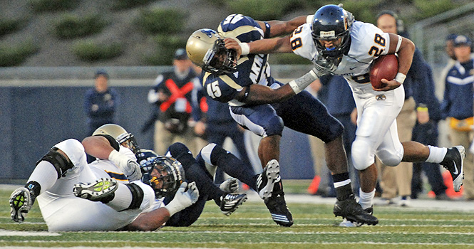 Freshman running back Anthony Meray blocks a tackle as he runs the ball downfield during the Saturday, Nov. 12 game at Infocision Stadium. The Flashes beat the Zips 35-3. File photo by Matt Hafley.