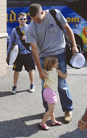 Keaton Stricklin, daughter of head coach Scott Stricklin, hugs one of Kent's baseball players at Dix Stadium on Monday, June 4. Family and fans gathered to welcome the team home after its first ever NCAA regional title. The Flashes will play the Oregon Ducks in a three-game series beginning Friday, June 8. Photo by Jenna Watson.