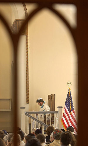 Rabbi Avi Winokur of Society Hill Synagogue, in Philadelphia, Pennsylvania, is framed through glass at the back of the sanctuary, Monday, September 16, 2002, during the celebration of Yom Kippur, which began at sunset on Sunday and ends at sundown on Monday. Photo courtesy of MCT Campus