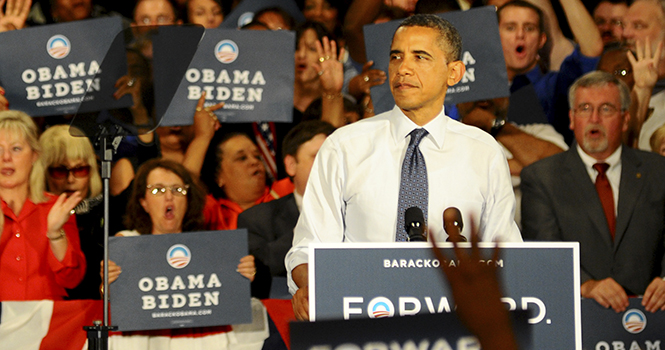 Obama supporters hold up four fingers and chant 'four more years!' at the John S. Knight Center Wednesday. Photo by Laura Fong.