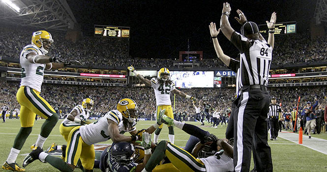 Referees signal different calls after Monday night's game-ending play. It was finally ruled a touchdown, giving the Seahawks a 14-12 win to defeat the Green Bay Packers at CenturyLink Field on Monday, September 24, 2012, in Seattle, Washington. Photo courtesy of MCT Campus.