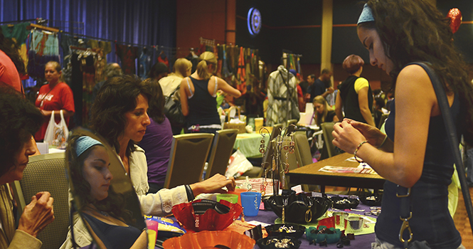 Meaghan Gick, a freshmen zoology major, examines a piece of jewelry at the Black Squirrel Festival. The event features many different storefronts ranging widely in products being sold, will be held on Friday. Photo by Jacob Byk.