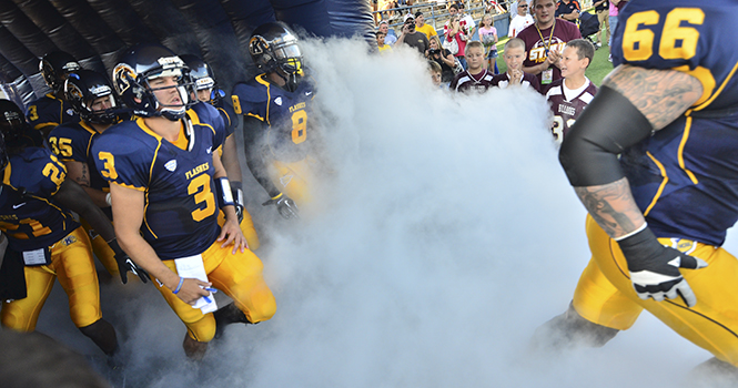 Quarterback Spencer Keith, number 3, runs onto the field with the Flashes at their home opener against Towson. Keith completed 10 of 19 passes for a total gain of 82 yards in offense during the Flashes' 41-21 winning game against Towson. Photo by Jacob Byk.