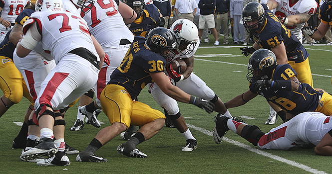 Senior linebacker Luke Batton (30) stops Ball State's ball runner during Kent's 45-43 win over the Cardinals on September 29. Batton was named Mid-American Conference East Division Defensive Player of the Week on October 29.. Photo by Brian Smith.