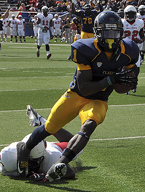 Senior running back/wide reciever Dri Archer evades a Ball State defender to cross the goal line and help lead the Golden Flashes to a 45-43 victory at Saturday's game at Dix Stadium. Archer had a stellar game, running for 104 yards and scoring two rushing touchdowns and one 99-yard kickoff return touchdown for the Flashes. Photo by Jessica Denton.