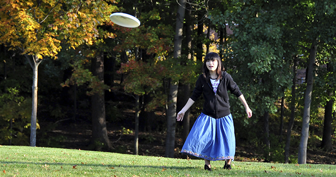 Mio Suzuki, an exchange student from Japan, learns and practices to how play Ultimate Frisbee on the Centennial field Thursday evening. Suzuki decided to join in with the newly created Kent State Women's Ultimate Frisbee team after watching the team practice. Photo by Jessica Denton.