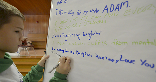 Brayden Wadsworth, 13 from Twinsburg, wrote on an easel at the Portage county National Alliance for Mental Illness Walk for Recovery, which raised awareness about those who suffer from mental illness. Brayden's sister has bipolar disorder, and his younger brother is autistic. Photo by Jacob Byk