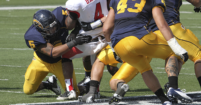 Ball State's Horactio Banks is tackled by junior defensive lineman Roosevelt Nix (#5) at Dix Stadium on Sept. 29. Nix was named MAC defensive player of the week on Nov. 5, 2012. Photo by Brian Smith.