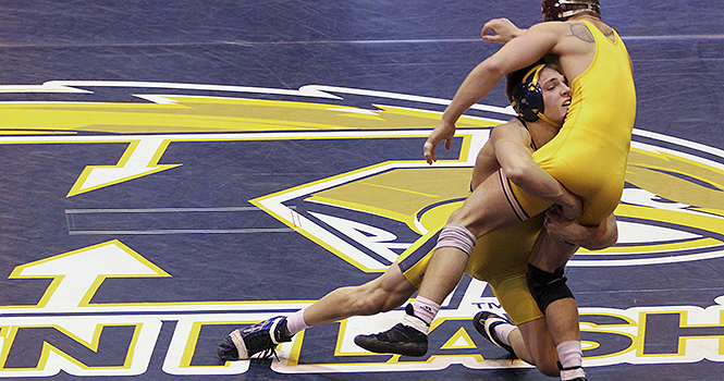 Freshman Ian Miller wrestles down Central Michigan's Joey Kielbasa during Sunday's meet at the M.A.C. Center. Miller won the match by major decision. Kent State beat Central Michigan 22-13. Photo by ANTHONY VENCE.