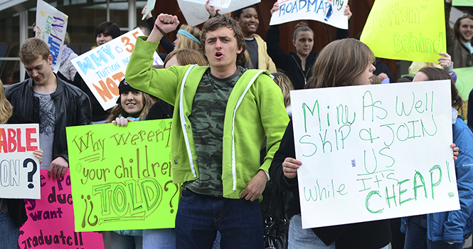 Vladimir Lovitz, freshman painting major, protests with students against the new credit hour fee outside the library on April 12, 2012. Photo by Nancy Urchak.