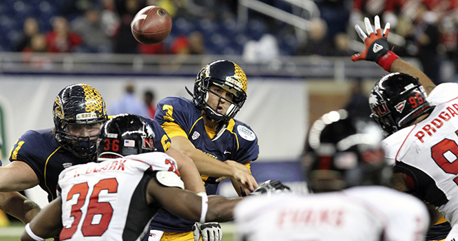 Senior quarterback Spencer Keith throws the ball before being tackled by the linemen of Northern Illinois University during the MAC Championship game held in Detroit Michigan, Friday, November 30. Photo by PHILIP BOTTA.