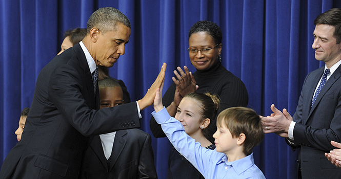 U.S. President Barack Obama gives high-fives to Grant Fritz after signing a series of executive orders about the administration's new gun law proposals in the Eisenhower Executive Office building January 16, 2013 in Washington, DC. Photo courtesy of MCT Campus.