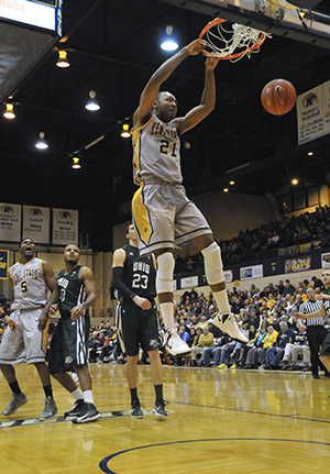 Kent State Men's Basketball forward Khaliq Spicer hangs from the rim aftering dunking during Saturday night's game against Ohio University in the MAC Center. The Golden Flashes lost to the Bobcats, 69-69, in an intense last-second game.. Photo by Jessica Denton.