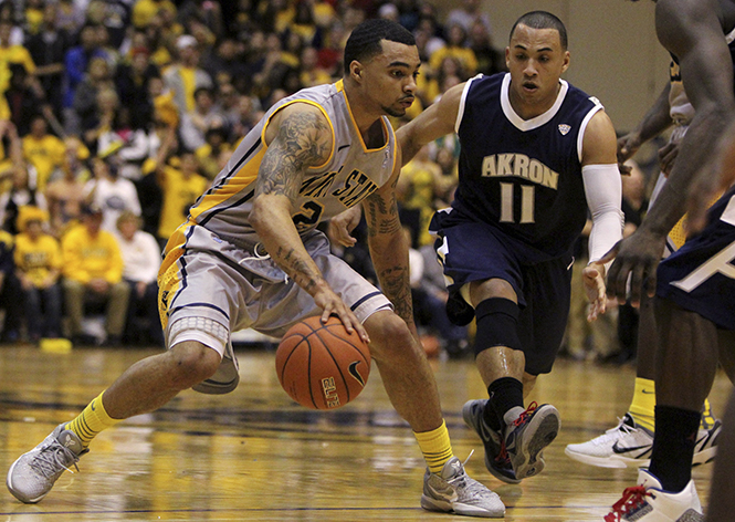 Senior Guard Michael Porrini dribbles the ball past Sophomore Guard Alex Abreu in the MAC center on March 2, 2012. The Zips defeated the Flashes 61 to 55. Photo by Adrianne Bastas.