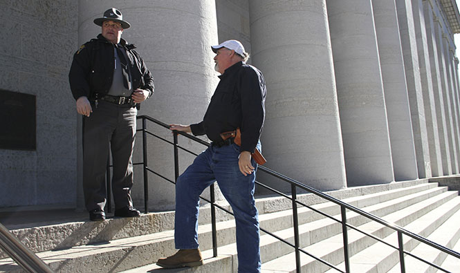 Phil Ouellette, 54, of Westerville speaks with an Ohio State Highway Patrol officer on the steps of the Ohio Statehouse in downtown Columbus during the Guns Across America rally Saturday, Jan.19. Ouellette, a gun owner himself, came out to support his 2nd amendment rights. "Until something bad happens to you or someone you know, it’s hard to take [gun rights] that seriously," he said. Photo by Shane Flanigan.