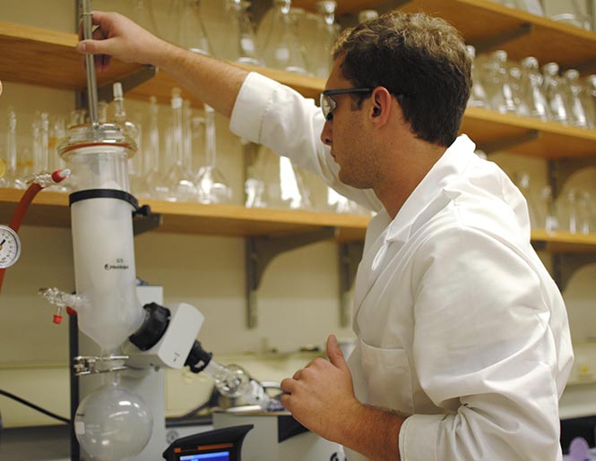 Junior biotechnology major Alek Nielsen adds more dry ice to a "roto vap" during research in the biomaterials lab in the liquid crystal building on Friday, September 14. The "roto vap" evaporates solvants to get a more concentrated product. The project involves stem cell research and could last for 5-6 years. Photo by JENNA WATSON.