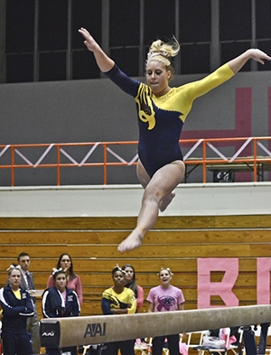 Kent State Sophomore Whitnee Johnson jumps on the balancing beam at Bowling Green on Feb. 2. Kent State won the match against Bowling Green 195.8 – 193.825. Photo courtesy of Molly McFadden of The BG News.