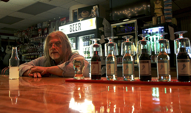 Woody James, 61, opened the Ohio Music Shop in downtown Kent almost three years ago and has been making guitars for the past 28 years. James, who first picked up a guitar at age six, has played with artists such as Glenn Hughes (Deep Purple), Gilby Clarke (Guns 'n Roses) and Elliot Eastman (The Cars) over his muscial career. Photo by Shane Flanigan.