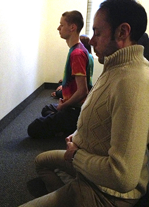 Luis Garcia, visiting scholar from Spain, and Sophomore Communication Studies major Benjamin Capka practice "sitting;" a form of Zen Buddhist meditation. Photo by Rachael Le Goubin.