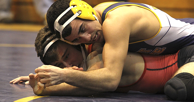 Senior Stevie Mitcheff pries Wisconsin's Matthew Cavallaris' hand from the mat during their match Sunday, Feb. 17 at the MACC as part of the NWCA National Duals. Kent State defeated Wisconsin in the meet 33-10, finishing in third place overall behind Oklahoma State and Northern Iowa. Photo by Shane Flanigan.