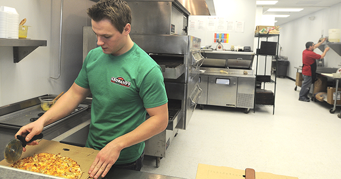 Josh Kostraba, senior accounting and management major, prepares a pizza in Georgio's, a new pizza parlor in dowtown Kent that gives away free food for promotion, on March 3, 2013. Photo by Jacob Byk.