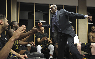 Assistant Coach DeAndre Haynes celebrates with the men's basketball team after their 70-68 victory over Buffalo in the MAC Tournament on Thursday, March 14 at Quicken Loans Arena in Cleveland. The win sets up a rematch with rival Akron in the semifinals Friday. Photo by Shane Flanigan.