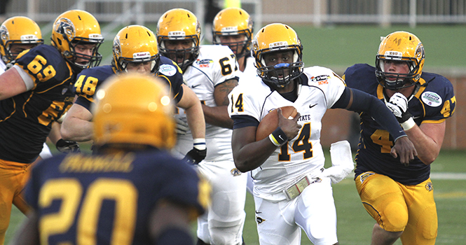 Sophomore quarterback Brett Maxie runs away from several Gold team defenders during the annual Spring Game at Dix Stadium on Saturday, April 27. The Blue overwhelmed the Gold, defeating them 31-0 in the exhibition game. Photo by Shane Flanigan