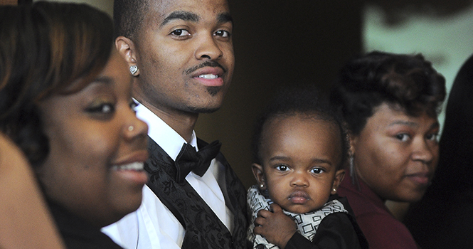 Jameel Davis a senior criminal justice major holds his 11-month-old son Jahier in the KIVA on Friday April 26, 2013. Davis was waiting before the start of Karamu Ya Wahitimu, a Swahili celebration of the final rights of passage before commencement. . Photo by Jacob Byk.