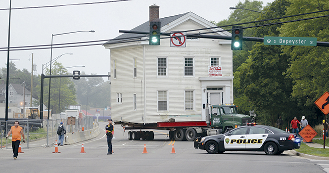 The Stein Movers company moves the Wells Sherman house down Haymaker Parkway on the morning of August 11. The house is now sitting at the west end of College Ave. while construction on the Esplanande extension is underway. Photo by Matt Hafley.