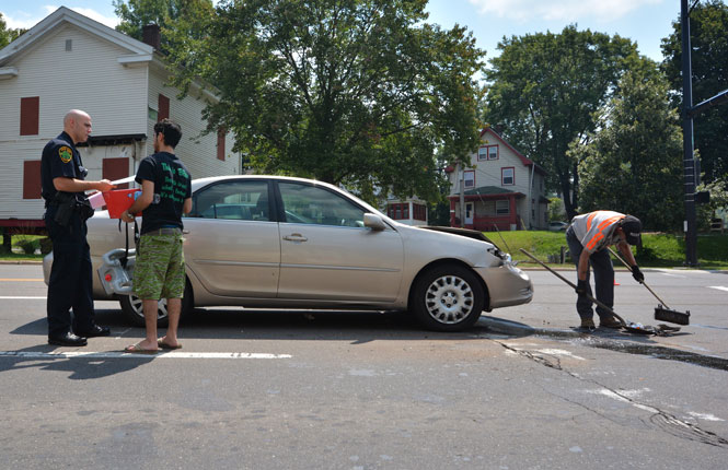 Tareq Mohammed, senior chemistry major, speaks with a Kent Police officer about a two-car traffic collision on the corner of S. Depeyster and Haymaker Parkway on Wed. afternoon. No one was seriously injured. Photo by Jacob Byk