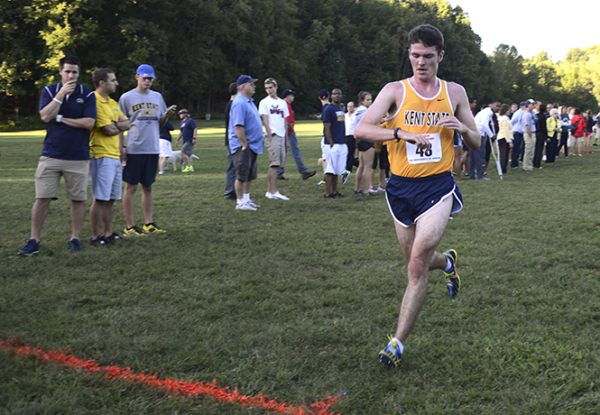 Kent State junior Adam Kendrick checks his time just before crossing the finish line at the Tommy Evans Invitational in Akron September 5, 2013. Photo by Melanie Nesteruk.